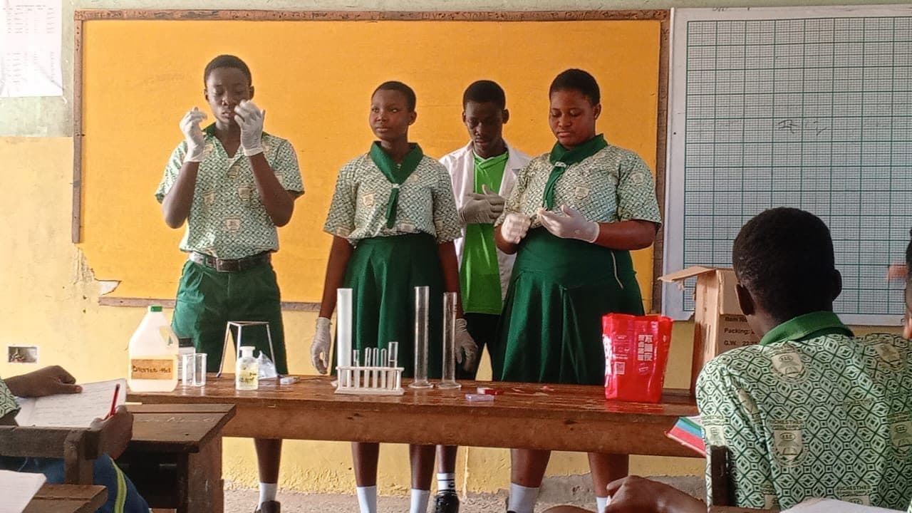 Students conducting a science experiment with test tubes in class