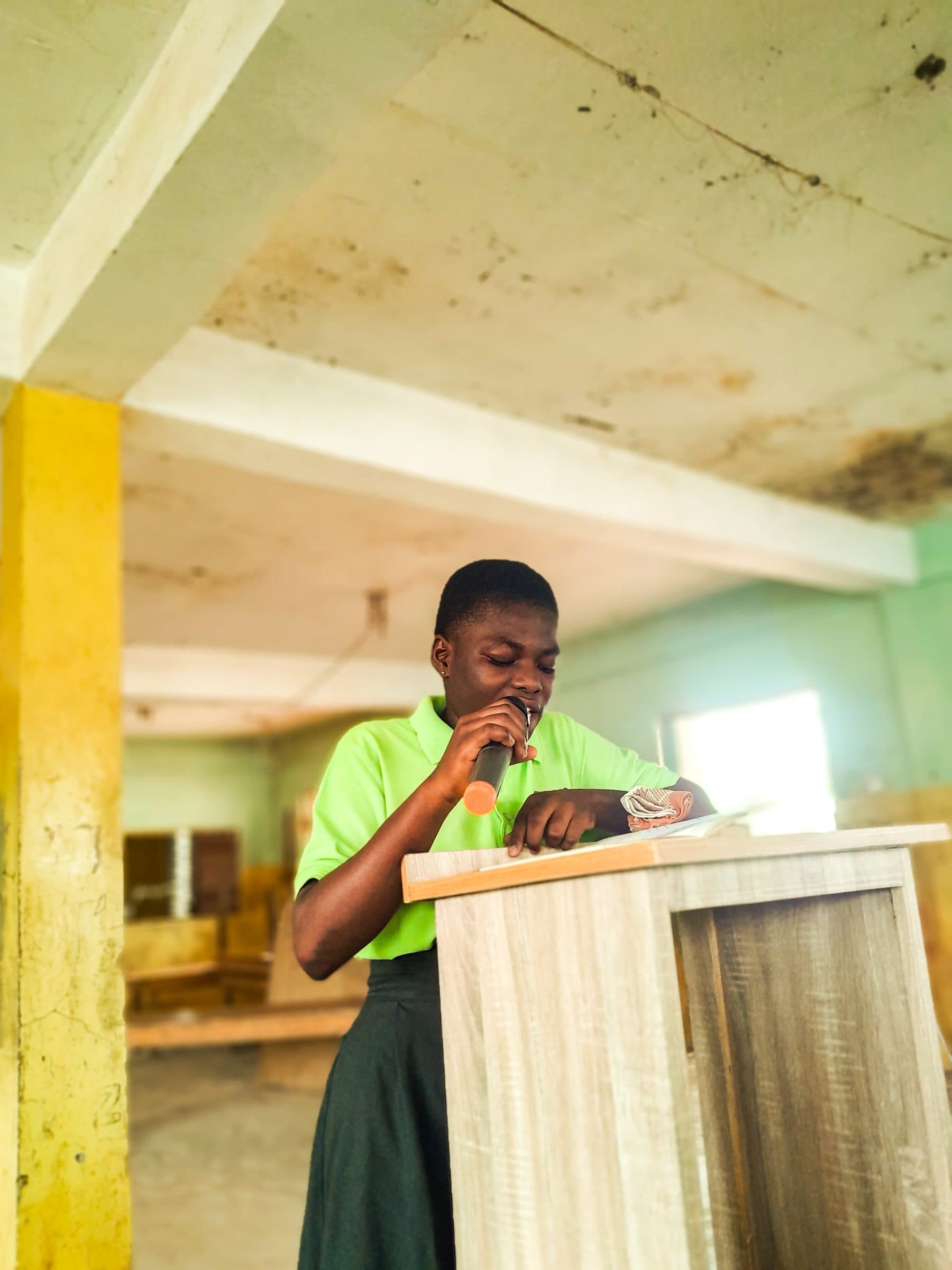 Student delivering a speech from a podium in the school hall